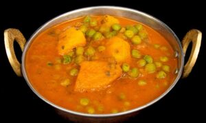 Aloo Matar curry with potatoes and green peas in spiced tomato gravy
