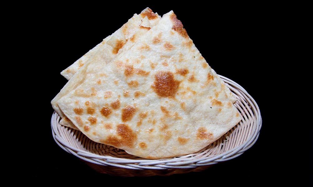 Soft butter naan fresh from the tandoor with a golden finish