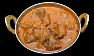 Rich and aromatic lamb rogan josh curry garnished with fresh cilantro