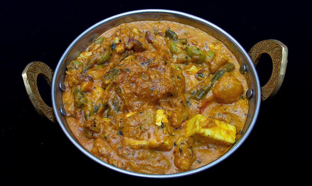 Colorful Navratna Korma with mixed vegetables and nuts in creamy sauce