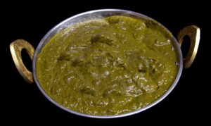 Grilled chicken tikka pieces cooked in creamy spinach saag gravy with spices