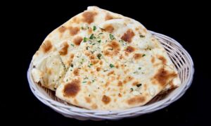 Freshly baked garlic naan Indian flatbread served hot