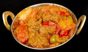 Tender lamb cooked in a rich tomato-based karahi sauce with peppers and spices – Indian Bites in Lyons